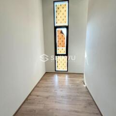 Small room with wooden flooring and tall window