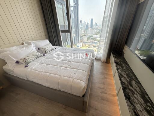 Modern bedroom with a large window and city view