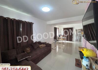 Living room with a sectional sofa, TV, and large windows with dark curtains