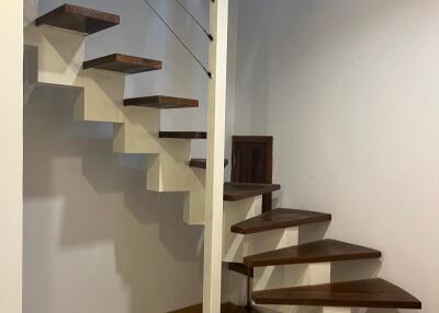 Interior staircase with wooden steps and metal railings