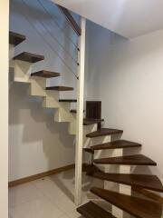 Interior staircase with wooden steps and metal railings