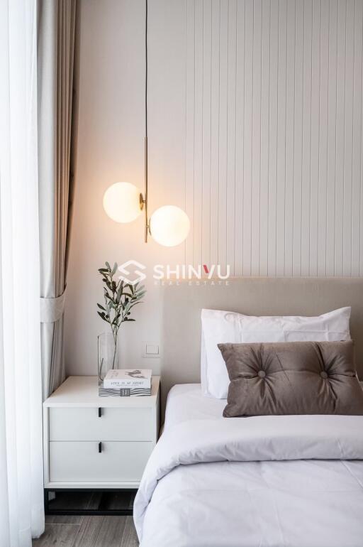 Modern and cozy bedroom with bedside table, lamp, and decor items