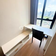 Small office space with a desk, chair, and city view through large windows