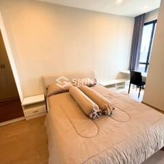 Bedroom with bed, desk, chair, large window, and closet