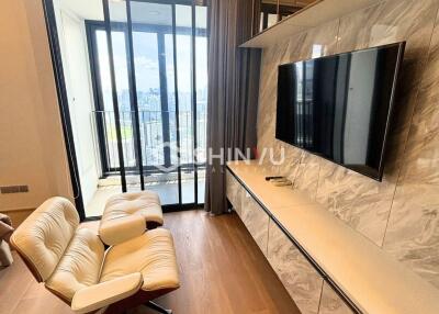 Modern living room with a large window, TV, and comfortable seating