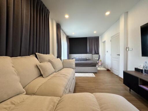 Spacious bedroom with beige couch and bed