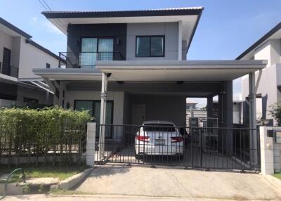 Two-story house with a driveway and car parked