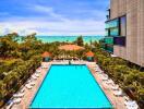 Large outdoor swimming pool with lounging area and ocean view