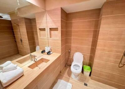 Modern bathroom with toilet, sink, and mirror