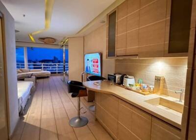 Modern kitchen with wooden cabinets and a view into the living area