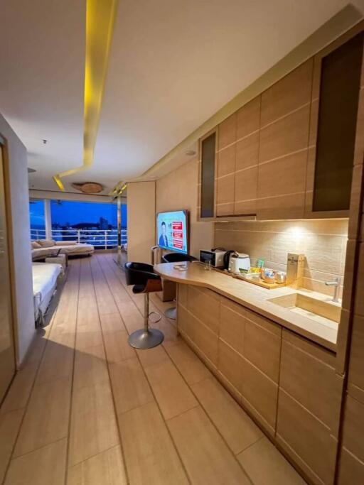 Modern kitchen with wooden cabinets and a view into the living area