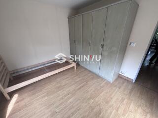 Empty bedroom with wooden flooring and large wardrobe