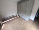 Empty bedroom with wooden flooring and large wardrobe