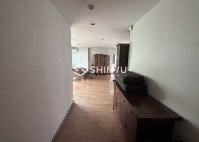 Interior hallway leading to a living room with wooden flooring