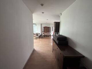 Interior hallway leading to a living room with wooden flooring