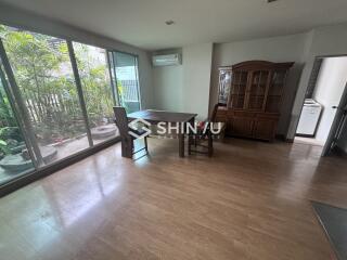 Dining area with wooden furniture, large windows, and a view of a garden