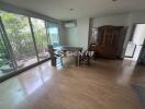 Dining area with wooden furniture, large windows, and a view of a garden