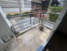 Outdoor balcony with a view of neighboring buildings.