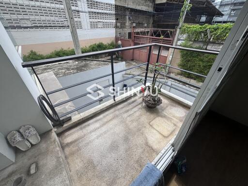 Outdoor balcony with a view of neighboring buildings.