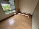 Empty bedroom with wooden flooring and single bed frame