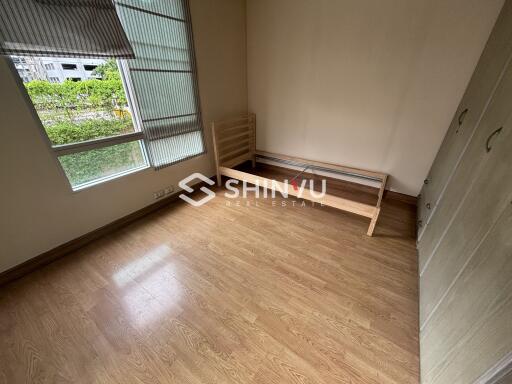 Empty bedroom with wooden flooring and single bed frame