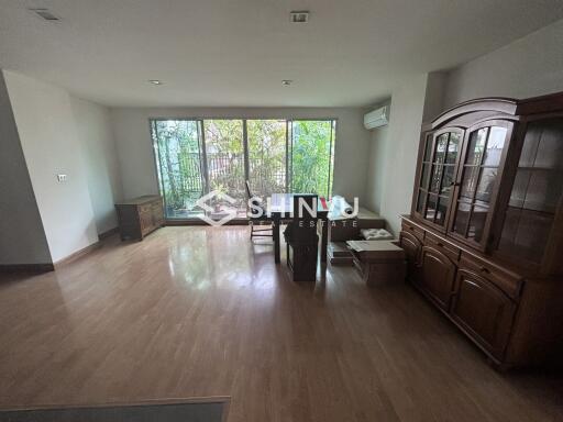 Spacious living room with large windows and wooden furniture