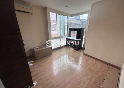 Bedroom with wooden flooring and a large window