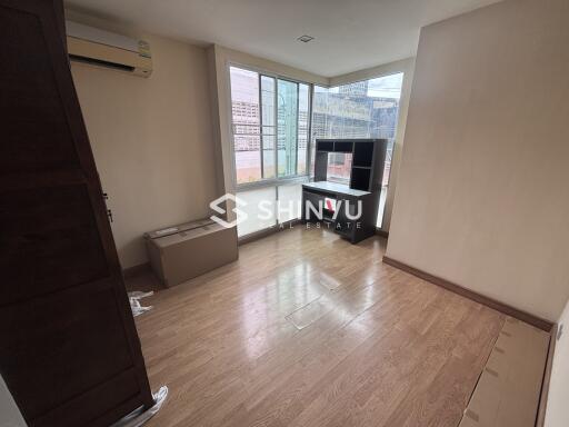 Bedroom with wooden flooring and a large window