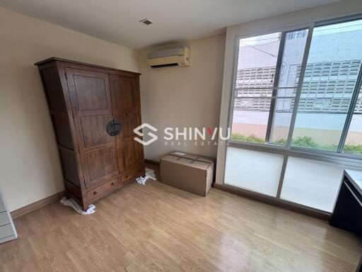 Bedroom with wooden wardrobe and large window