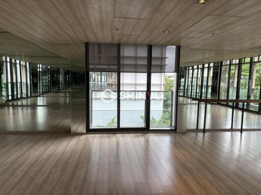 Spacious room with large windows and mirrored walls