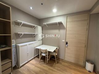 Small dining area with table and chairs next to storage cabinets