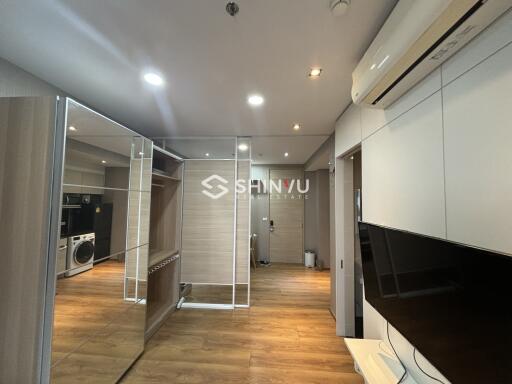 Modern living area with wooden flooring and mirrored closet