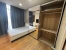 Modern bedroom with bed, mirrored wardrobe, and wooden floor