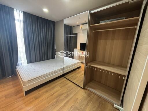 Modern bedroom with bed, mirrored wardrobe, and wooden floor