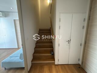 View of an indoor staircase area next to a living space with a partial view of a light blue sofa