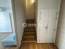 View of an indoor staircase area next to a living space with a partial view of a light blue sofa