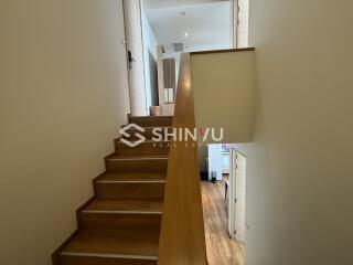 Staircase with wooden steps leading to upper floor hallway