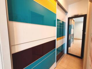 Hallway with colorful sliding doors and a mirror