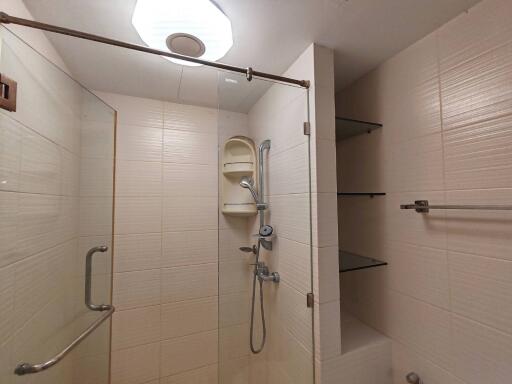 Shower area with glass door and shelves