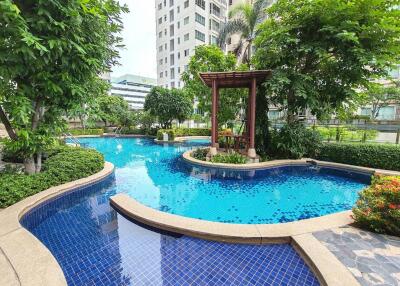 Swimming pool surrounded by greenery and buildings