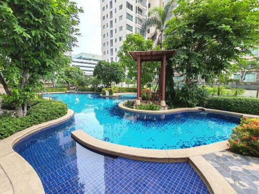 Swimming pool surrounded by greenery and buildings