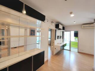 Bright and modern living area with built-in shelving and adjacent balcony