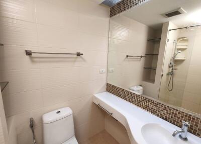 Modern bathroom with large mirror and wall-mounted fixtures