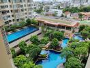 View of residential building with swimming pools and lush greenery