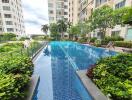 Swimming pool surrounded by lush greenery and apartment buildings