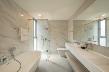 Modern bathroom with freestanding bathtub, walk-in shower, and large vanity mirror