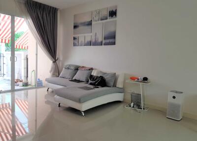 Modern living room with a sectional sofa, wall art, and view of the balcony