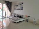 Modern living room with a sectional sofa, wall art, and view of the balcony