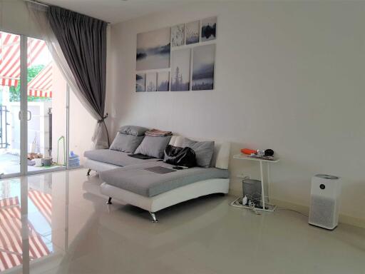 Modern living room with a sectional sofa, wall art, and view of the balcony