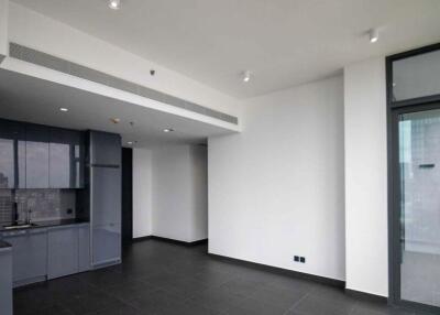 Modern open-plan living area with dark tile flooring and large windows